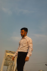 Man poses on an old bridge.