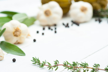 Fototapeta na wymiar raw tagliatelle pasta, garlic and spice leaves on white wood table background