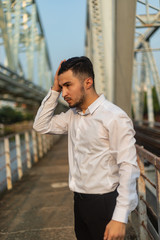 Man poses on an old bridge.