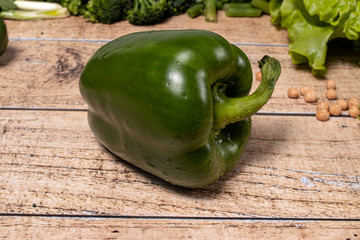 
Green healthy peppers on a brown wooden background. Products for the keto diet, gluten-free diet and proper nutrition for weight loss.