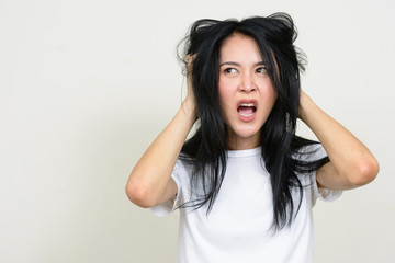 Fototapeta premium Portrait of stressed young Asian woman tearing hair out