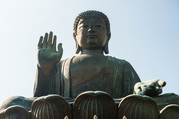 Fototapeta premium Beautiful shot of the the famous Tian Tan Buddha (Big Buddha, a large bronze statue of Buddha Shakyamuni) on Lantau Island. Nobody. Sunny day. Low angle. 
