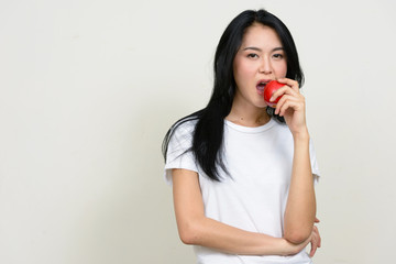 Portrait of young beautiful Asian woman eating apple