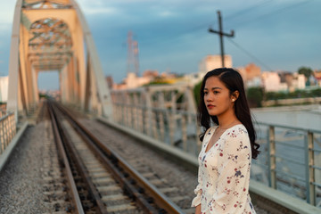 Vietnamese girl standing on an old bridge