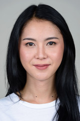 Fototapeta premium Face of young beautiful Asian woman looking at camera