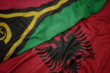 waving colorful flag of albania and national flag of Vanuatu .