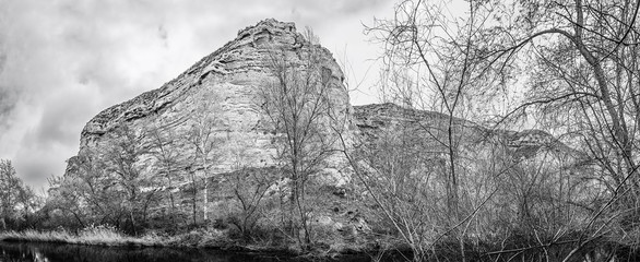 Fototapeta na wymiar Henares river as it passes through Alcalá de Henares in winter: panoramic view of mountain formation on the river bank.