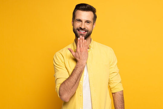 Smiling Man Looking At Camera While Showing Word Speak In Sign Language On Yellow Background