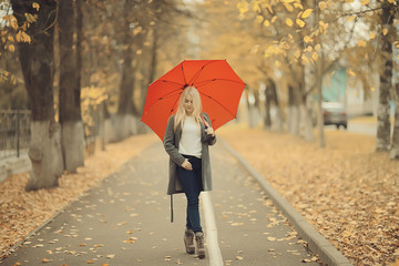 girl with umbrella posing in autumn park, october landscape lonely woman holding a red umbrella