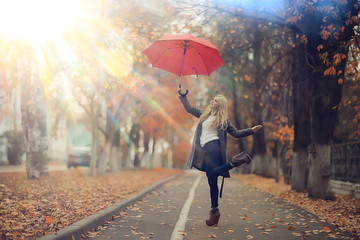 autumn look, sunny day a young girl with an umbrella walks in a yellow park in October