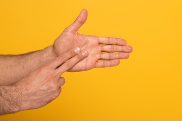 Naklejka premium Cropped view of man showing gesture in deaf and dumb language with hands isolated on yellow