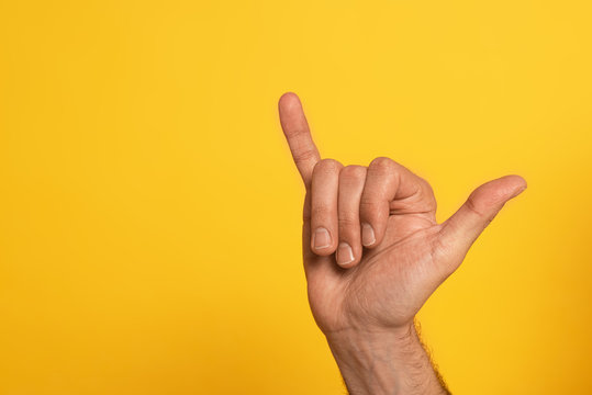 Cropped view of man showing cyrillic letter from alphabet of sign language isolated on yellow