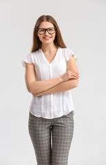 Portrait of beautiful young businesswoman on light background