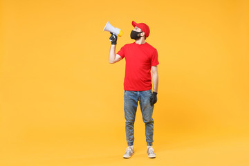 Delivery man in red cap blank t-shirt uniform mask gloves isolated on yellow background studio Guy fun employee working courier scream in megaphone Service pandemic coronavirus virus 2019-ncov concept