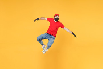 Naklejka na ściany i meble Fun jumping delivery man in red cap t-shirt uniform sterile face mask gloves isolated on yellow background studio Guy employee courier Service quarantine pandemic coronavirus virus 2019-ncov concept.