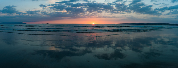 Dusk sunset light beach reflection Panorama, empty quite beach on the west coast of Ireland, wild Atlantic way