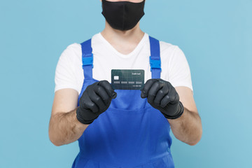 Delivery man in cap t-shirt uniform sterile mask glove isolated on blue background studio Guy employee courier hold credit card Service quarantine pandemic coronavirus virus covid-19 2019-ncov concept