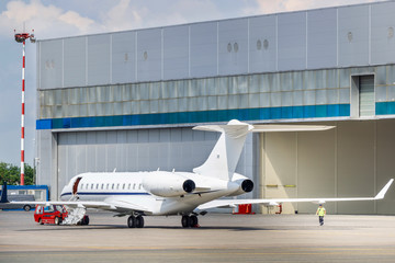 Private charter jet with the open airstairs in front of the hangar