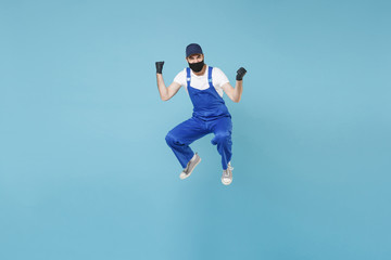 Obraz premium Fun jumping delivery man in cap t-shirt uniform sterile face mask glove isolated on blue background studio Guy employee courier Service quarantine pandemic coronavirus virus covid-19 2019-ncov concept