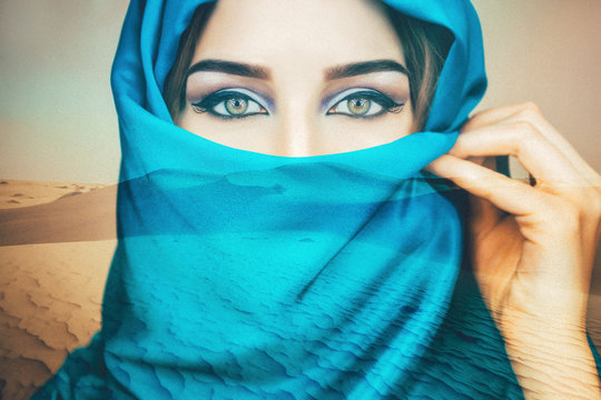 Arabian woman in the blue scarf closeup on the desert background. Double exposure
