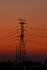 Fototapeta premium Vertical image, high voltage pole in the middle of the frame During Twilight Life There is beautiful light. Suitable for use as illustrations of content.