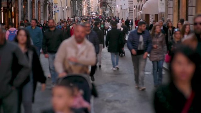 Video of anonymous crowd walking in Rome. Busy street, full of tourist and business people. Beautiful old buildings and calm atmosphere. 4K video.
