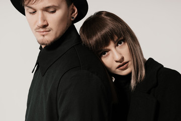 Portrait of urban fashion beautiful couple in black clothes posing over white background together. Close up fashion portrait of stylish young couple pretty woman and handsome man