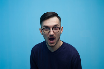 Portrait of an emotional young man in glasses