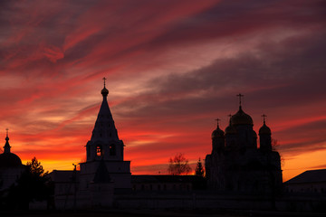 Obraz premium The black silhouette of the monastery against the bright sunset sky.