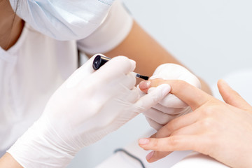 Hand covers varnish to nail.