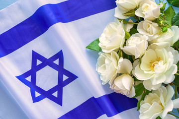 Flag of Israel and white roses. Independence Day celebration.