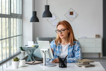 Mature woman using tablet computer for online learning at home