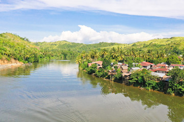 Obraz premium River and green hills. Beautiful natural scenery of river in southeast Asia. The nature of the Philippines.