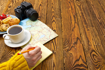 light breakfast, fresh pastries and coffee, on an old wooden table. tourist concept. Travel blogger breakfast building a route plan with cup of coffee
