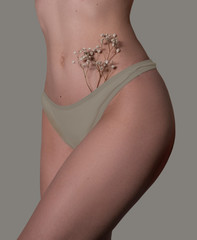 Beautiful photo of a bikini area. Flowers in underpants.
Moles on a half-naked body. Flowers in the bikini zone. 