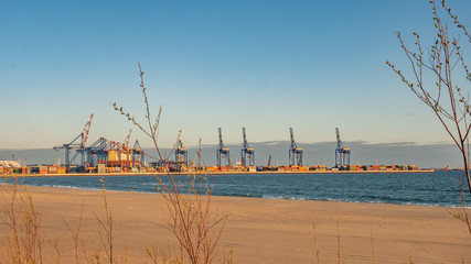 Stogi beach with dunes and deep water terminal (DCT Gdansk, Poland. Container facility). - obrazy, fototapety, plakaty