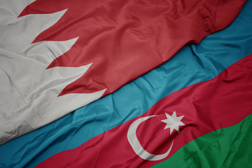 waving colorful flag of azerbaijan and national flag of bahrain.