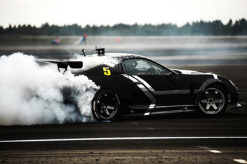  a sports car drifts tires on asphalt on a racetrack © AvokadoStudio