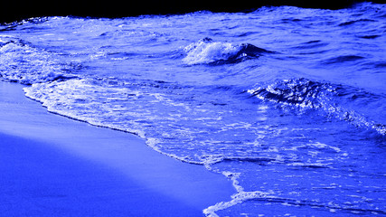 tinted blue saturated color. blue waves of the surf on the beach. trendy colors 2020.