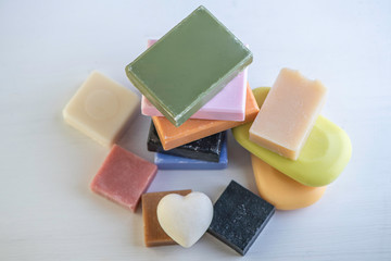selection of colorful  natural rose olive orange carbon coal charcoal black soap bar block isolated on white background 