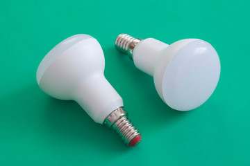 LED lamps on green background. Low power ecology friendly bulb lamps for household usage. Point...