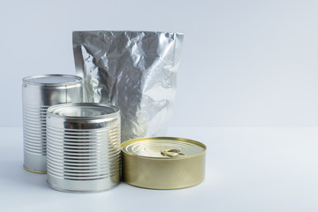 Metal cans of different sizes, metallized flexible packet on a white background. A variety of...