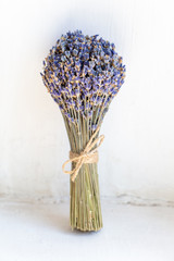 Small cute bouquet of fragrant dried lavender tied with thread on a white background
