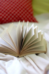 Open book on a bed. Selective focus.