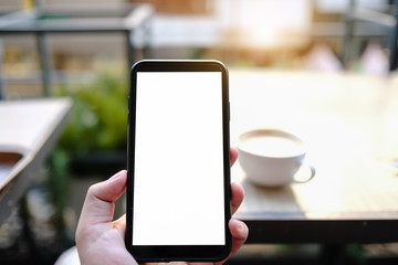 Mockup image of a woman holding and showing black mobile phone with blank screen in cafe.