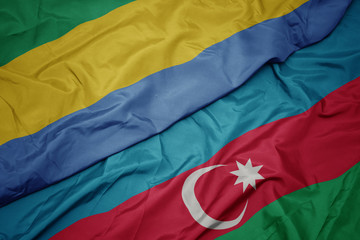 waving colorful flag of azerbaijan and national flag of gabon.