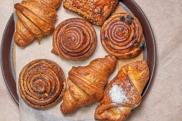 A flat round plate with different buns. The view from the top