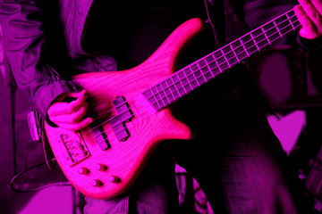 Fototapeta na wymiar Life style image of close up young man hand, playing electric bass guitar