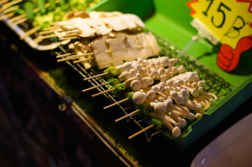 bbq stick, small baby mushroom in the sticks at local street food in night market, thailand