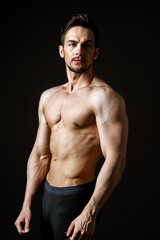 Fototapeta na wymiar Portrait of an attractive muscular man on a dark background